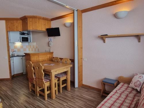 une petite cuisine et salle à manger avec une table et des chaises dans l'établissement Studio tout confort avec balcon, accès direct aux pistes - FR-1-181-2602, à Aime La Plagne