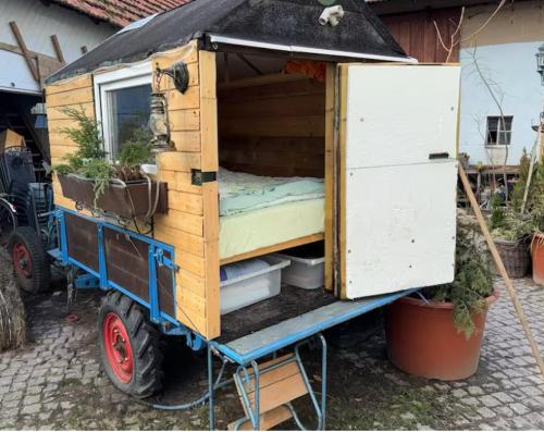 a small bed in a wooden house on a trailer at Schäferwagen Own Sleeping bag Gemeinschaftsbad Free WiFi in Hausbreitenbach