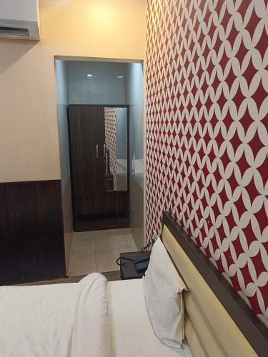 a bedroom with a bed and a red and white wall at Hotel Airport Gateway in Lucknow
