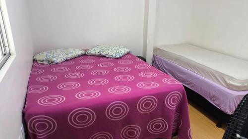 a purple bed with pillows on it in a room at Apartamento em Imbituba, praia da Vila in Imbituba