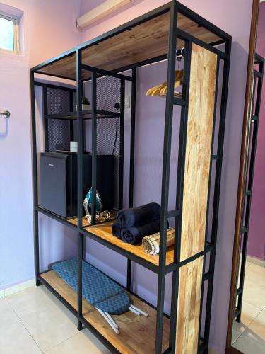 a shelf in a room with wooden and metal at Jas Telaga Inn Homestay in Teluk Mas