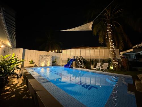 a large swimming pool at night with at Jas Telaga Inn Homestay in Teluk Mas