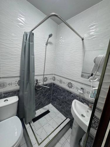 a bathroom with a shower and a toilet and a sink at Bekhzod in Bukhara