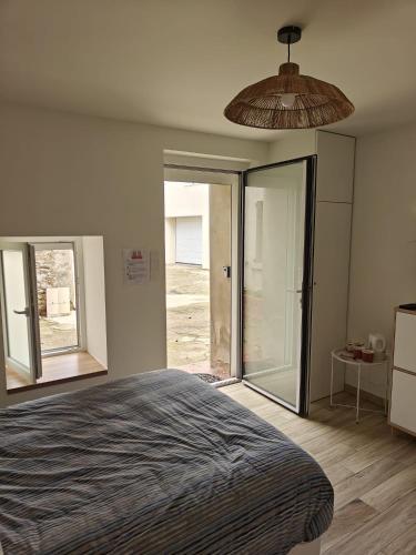 una camera da letto con un letto e porte scorrevoli in vetro di La maison de l'impasse a Chasse-sur-Rhône