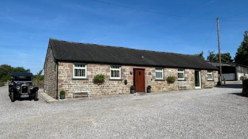 a brick building with a car parked in front of it at Stylish 2 Bed Near Alton Towers, Polar Bears, Peak District in Waterfall