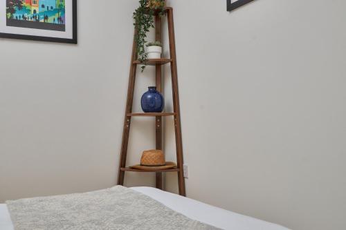 a wooden shelf with vases on it next to a bed at Wilford Place in Nottingham