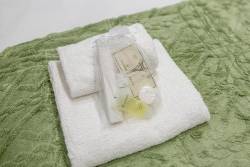 - une serviette blanche avec une bouteille et des pilules sur le lit dans l'établissement Amazing deal - Central Location near the metro, Modern amenities and style, à Paris