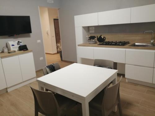 a kitchen with a table and a white table and chairs at Al Crocevia in Bologna