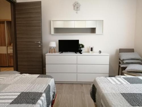 a bedroom with two beds and a tv on a dresser at Al Crocevia in Bologna