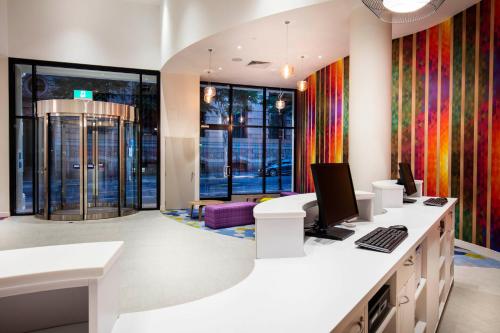 an office with a desk with a computer on it at ibis Styles Brisbane Elizabeth Street in Brisbane