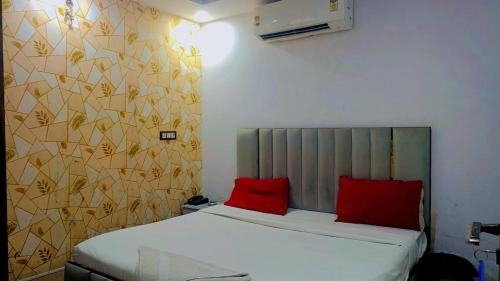 a bedroom with a bed with two red pillows at Hotel VCR INN in New Delhi