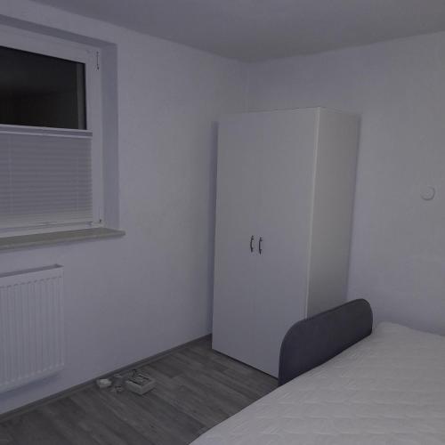 a room with a bed and a white refrigerator at Ferienwohnung für 2 Personen in Wustrow
