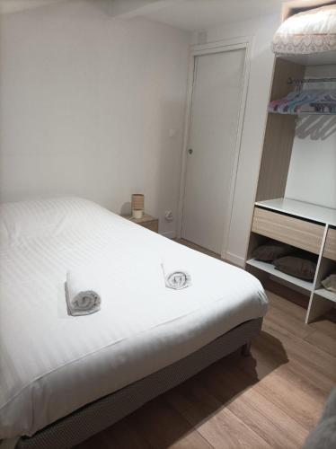 une chambre avec un lit blanc et un placard dans l'établissement L'Escapade, à Thonon-les-Bains
