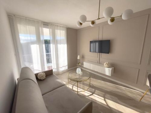 un salon avec un canapé et une table dans l'établissement Appartement Étoilé, Clim, Plage, Parking, Terrasse, à La Grande Motte