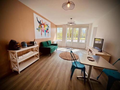 - un salon avec une table et un canapé vert dans l'établissement Niki, belle vue sur le Loiret, à Saint-Pryvé-Saint-Mesmin