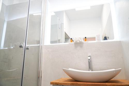 a bathroom with a white sink and a shower at EssenFusion Wasserturm - Innenstadt nahe der Messe, SmartTV, Nespresso, Fully Kitchen in Essen