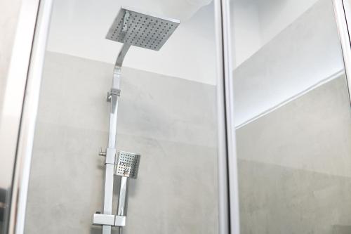 a shower with a light next to a glass door at EssenFusion Wasserturm - Innenstadt nahe der Messe, SmartTV, Nespresso, Fully Kitchen in Essen