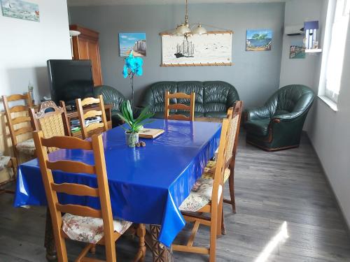 a dining room with a blue table and chairs at Maison haute 6 pers - plans d'eau centre-ville in LʼAiguillon-sur-Mer