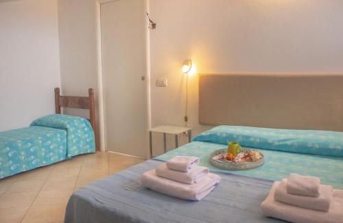 a room with two beds with towels on a table at Il Grottino in Stintino
