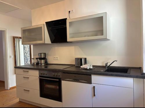 a kitchen with a sink and a microwave at Ferienwohnung EG AusZeit in Bad Bertrich