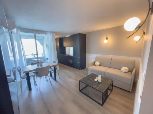 un salon avec un canapé et une table dans l'établissement T2 Étoilé, Clim, Chambre, Plage, Parking, Terrasse, à La Grande Motte