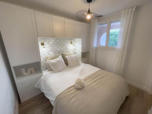 une chambre avec un lit blanc avec une fenêtre dans l'établissement T2 Étoilé, Clim, Chambre, Plage, Parking, Terrasse, à La Grande Motte