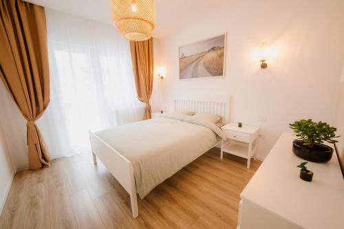 a bedroom with a white bed and a window at HARMONY Apartment - Grand Kristal Residence Bucharest in Bucharest