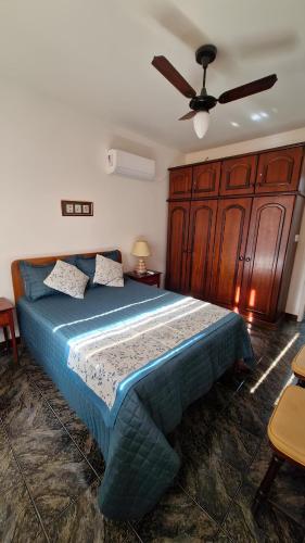 ein Schlafzimmer mit einem Bett mit Deckenventilator in der Unterkunft Localização Imbatível! A 98m da Praia do Forte com Conforto, Ar-Condicionado e Estacionamento! in Cabo Frio