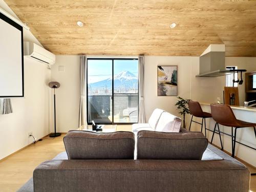 a living room with a couch and a large window at Hoco 富士急ハイランド in Funatsu