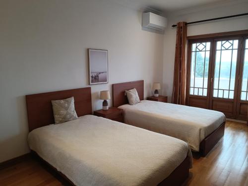 a hotel room with two beds and a window at Casa Grande in Golpilheira