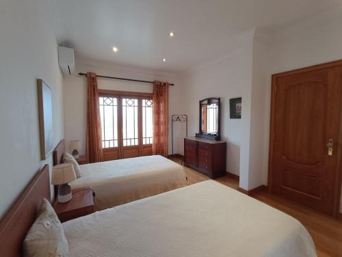 a bedroom with two beds and a television in it at Casa Grande in Golpilheira