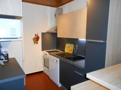 une petite cuisine avec un évier et une cuisinière dans l'établissement Appartement 8 pers, centre station, proche pistes et animations, balcon sud, parking privé - FR-1-516-5, à Les Deux Alpes