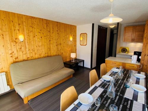 - un salon avec un lit et une table avec des chaises dans l'établissement Charmant T2 au pied des pistes avec balcon exposé sud, idéal pour 6 personnes, proche commerces! - FR-1-516-8, à Les Deux Alpes