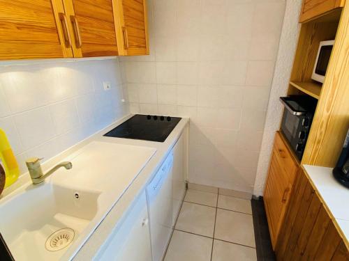 une petite cuisine avec un évier et un micro-ondes dans l'établissement Charmant T2 au pied des pistes avec balcon exposé sud, idéal pour 6 personnes, proche commerces! - FR-1-516-8, à Les Deux Alpes