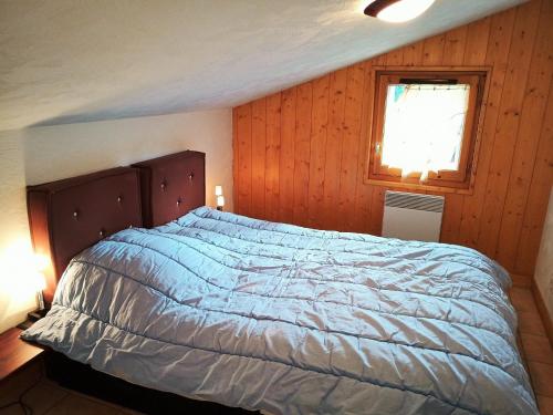 - une chambre avec un lit et un mur en bois dans l'établissement Charmant 3 pièces 6 pers proche pistes avec balcon - FR-1-516-11, à Les Deux Alpes
