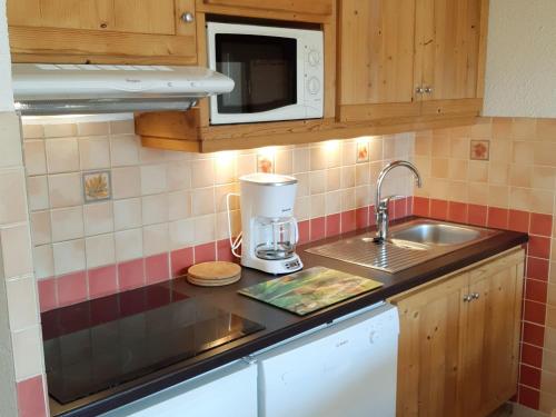 une cuisine avec un évier et un mixeur sur un comptoir dans l'établissement Appartement rénové aux Deux Alpes, pied des pistes, balcon, parking - FR-1-516-28, à Les Deux Alpes