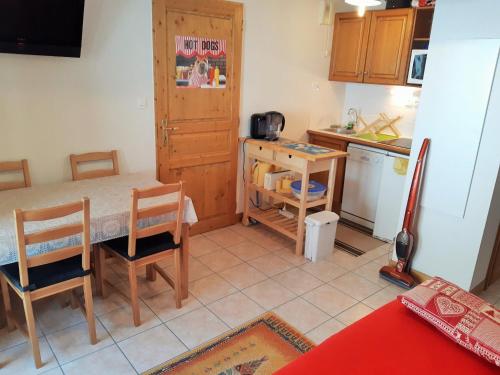 une cuisine avec une table, des chaises et un comptoir dans l'établissement Appartement 2 pièces avec balcon - Pied des pistes, secteur calme - FR-1-516-145, à Mont-de-Lans