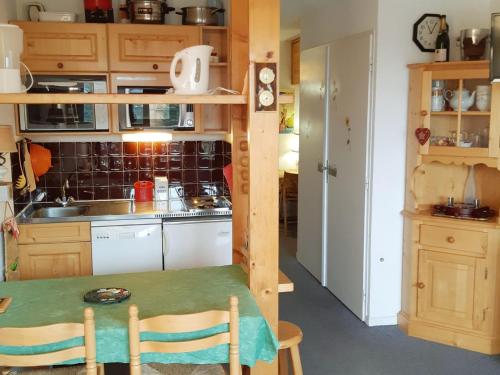 une petite cuisine avec une table dans une pièce dans l'établissement Studio cosy au pied des pistes avec balcon et parking - FR-1-516-103, à Les Deux Alpes