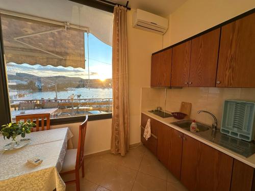 a kitchen with a table and a window with a view at Ion Sea View in Ksamil