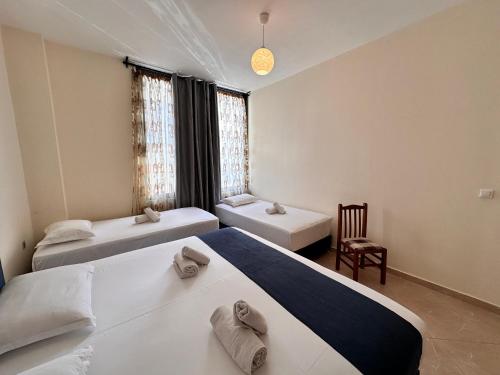 a room with two beds and a chair at Ion Sea View in Ksamil