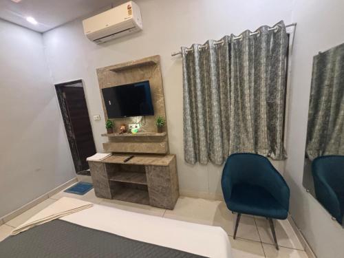 a living room with a tv and a blue chair at Hotel Jawahar Ji Pandya and Restaurant in Khātu