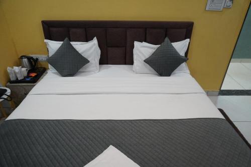 a large bed with white sheets and gray pillows at Hotel Jawahar Ji Pandya and Restaurant in Khātu
