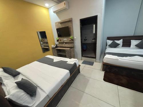 a bedroom with two beds and a television in it at Hotel Jawahar Ji Pandya and Restaurant in Khātu