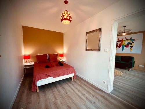 une chambre avec un lit avec une couette rouge dans l'établissement Niki, belle vue sur le Loiret, à Saint-Pryvé-Saint-Mesmin
