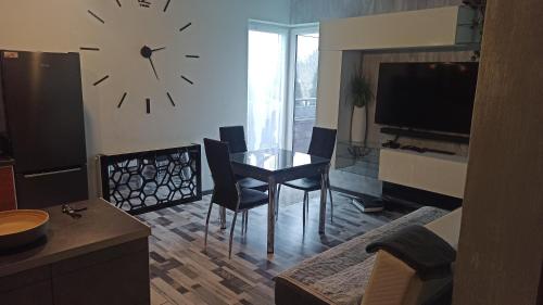 a living room with a table and a clock on the wall at Double bed studio with large terrace in Kutno