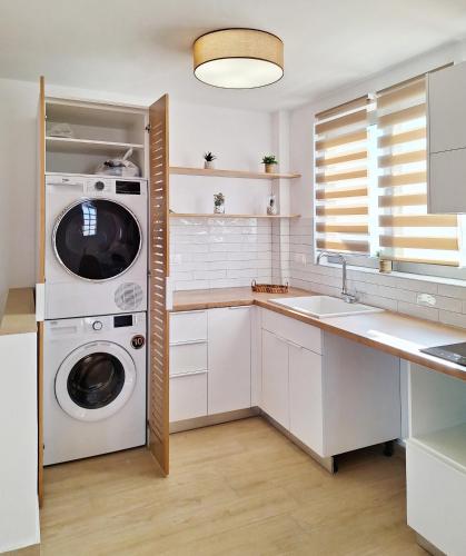 a white kitchen with a washer and dryer in it at Lux home in central location in Ierapetra