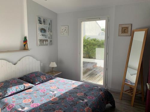 une chambre avec un lit et une grande fenêtre dans l'établissement Maison contemporaine aux Sables d 'Olonne, à Les Sables-dʼOlonne