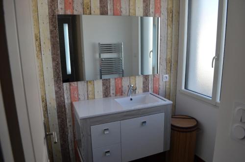 une salle de bain avec un lavabo et un miroir dans l'établissement Maison contemporaine aux Sables d 'Olonne, à Les Sables-dʼOlonne