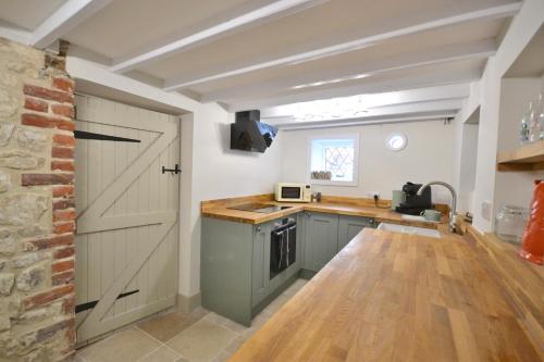 a kitchen with a barn door and a counter top at Albie Cottage in Grimston