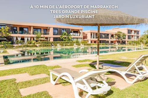 a pair of white chairs under an umbrella next to a pool at Lina cosy - Clim, Wifi, Jardin à 10min de l'Aéroport in Marrakech